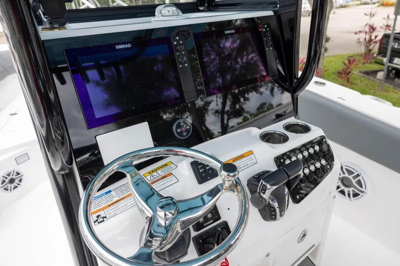 Slide: The Image of 2024 NauticStar 292 Legacy boat dashboard with steering wheel and navigation screens. - 11