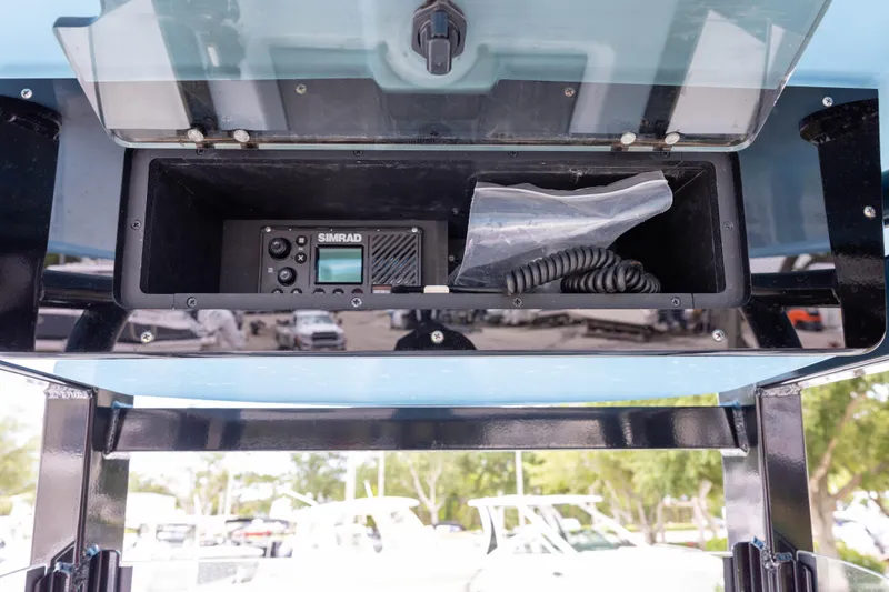 Slide: The Image of 2024 NauticStar 292 Legacy boat console with Simrad electronics and storage compartment. - 12