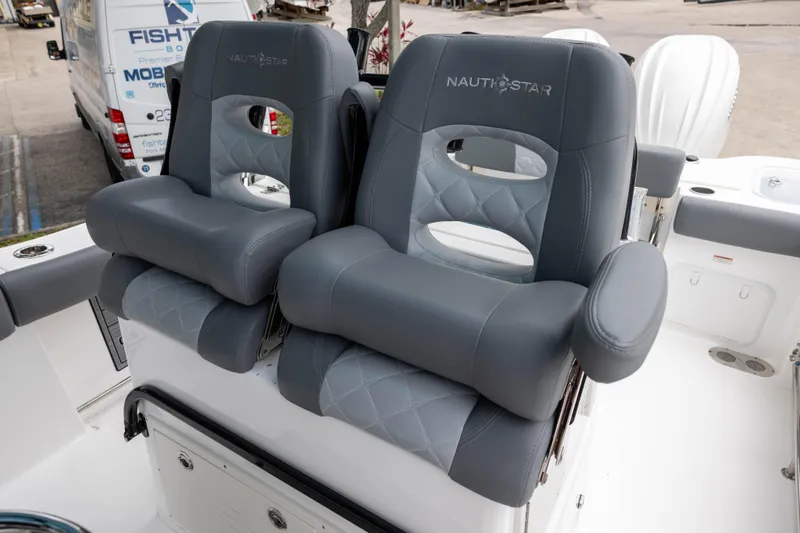 Slide: The Image of 2024 NauticStar 292 Legacy boat seats with gray upholstery and armrests. - 13