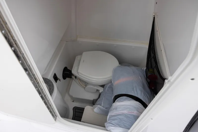 Slide: The Image of 2024 NauticStar 292 Legacy boat interior with compact marine toilet. - 16