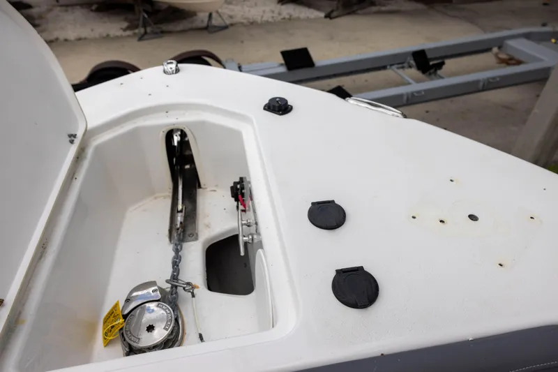 Slide: The Image of 2024 NauticStar 292 Legacy boat anchor compartment with winch and chain. - 17