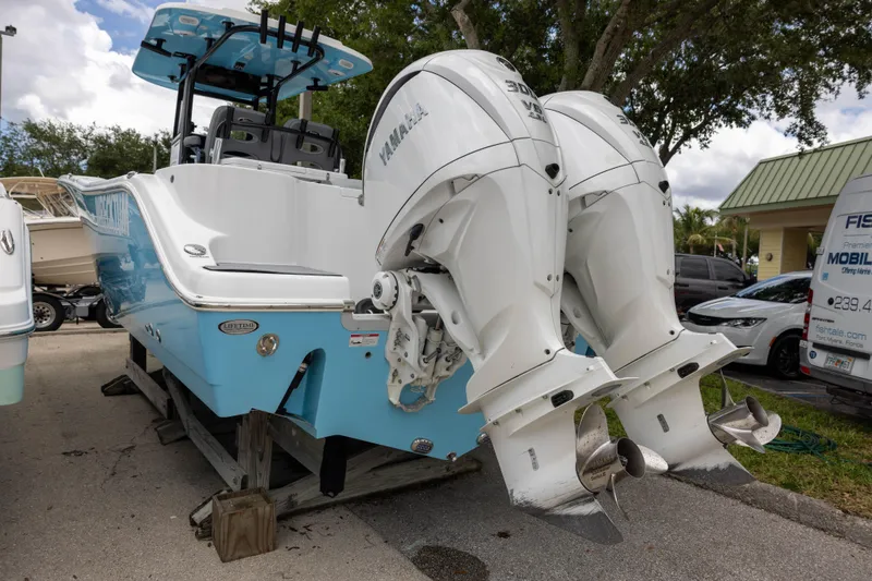 Slide: The Image of 2024 NauticStar 292 Legacy boat with dual Yamaha outboard engines, parked outdoors. - 2