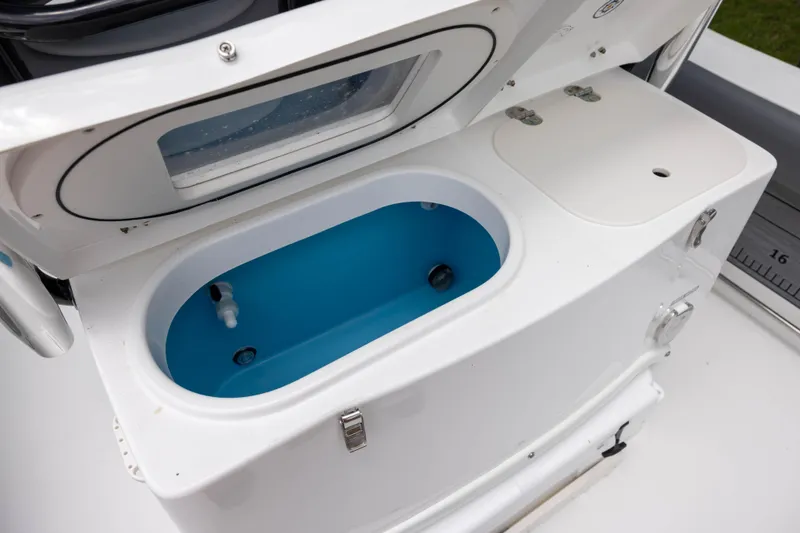 Slide: The Image of 2024 NauticStar 292 Legacy boat livewell with blue interior and secure latch. - 7