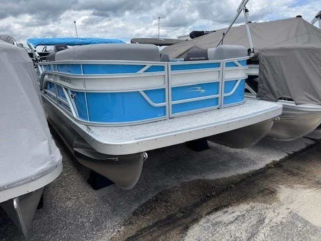 Slide: The Image of 2026 Bennington 20SL pontoon boat in blue on a parking lot. - 19