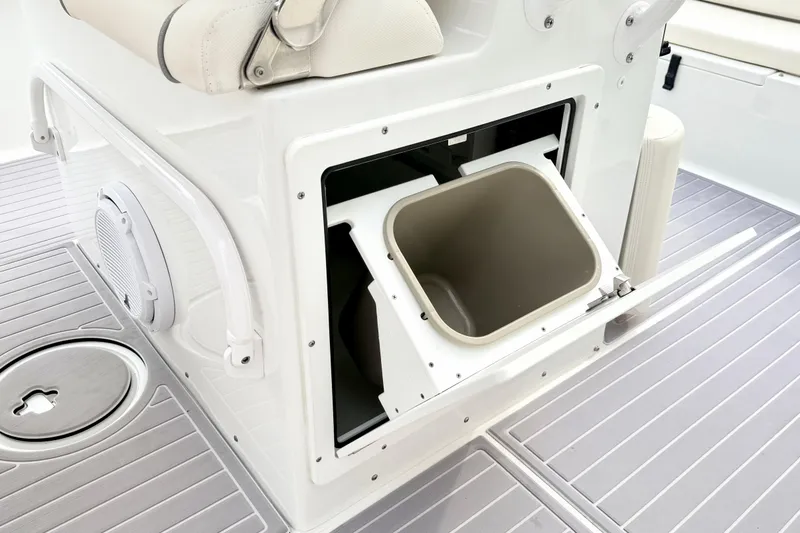 Slide: The Image of 2023 Sea Hunt Escape 28 boat interior with built-in storage compartment and trash bin. - 18