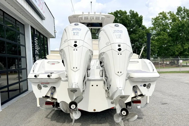 Slide: The Image of 2023 Sea Hunt Escape 28 boat with dual 300 V6 engines, parked outdoors. - 2