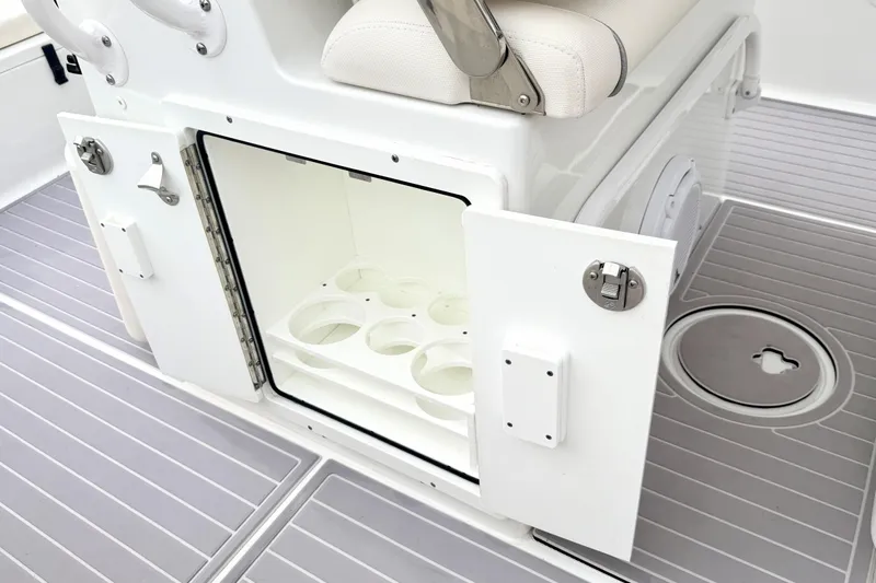 Slide: The Image of 2023 Sea Hunt Escape 28 boat interior with open storage compartment and cup holders. - 20