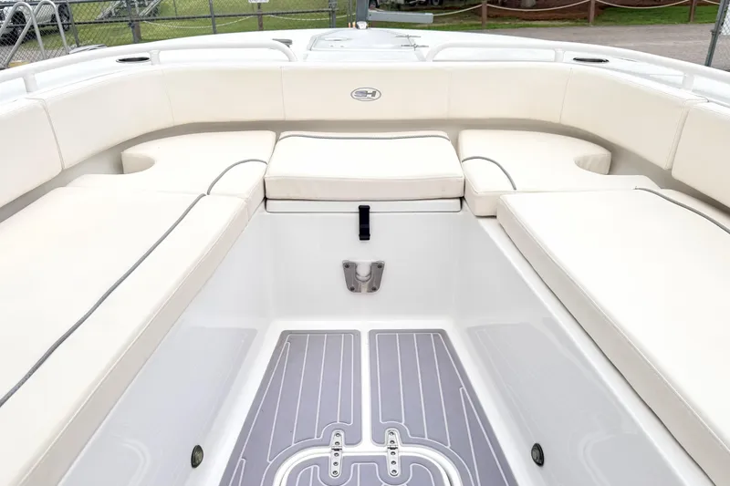Slide: The Image of 2023 Sea Hunt Escape 28 boat interior with white cushioned seating and sleek flooring. - 29