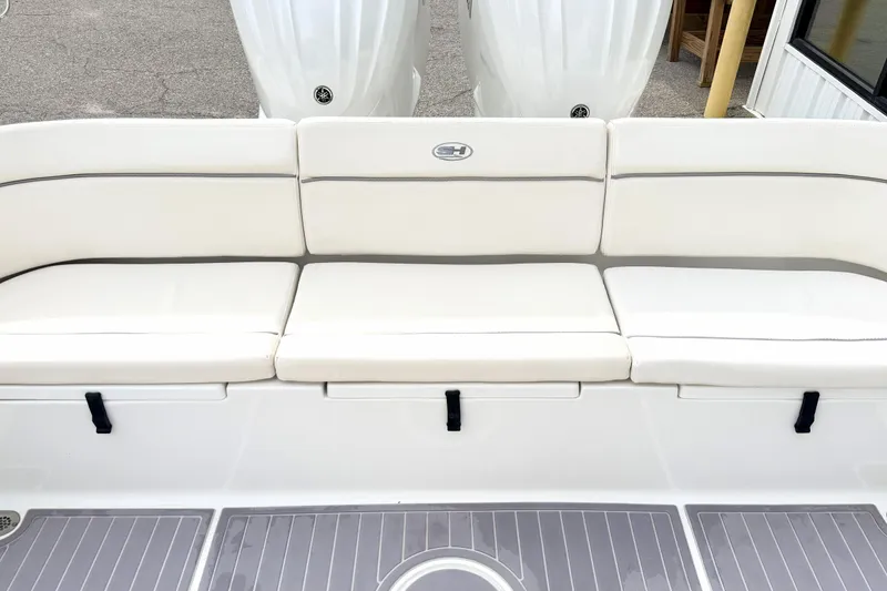 Slide: The Image of 2023 Sea Hunt Escape 28 boat with white cushioned seating and dual outboard motors. - 3