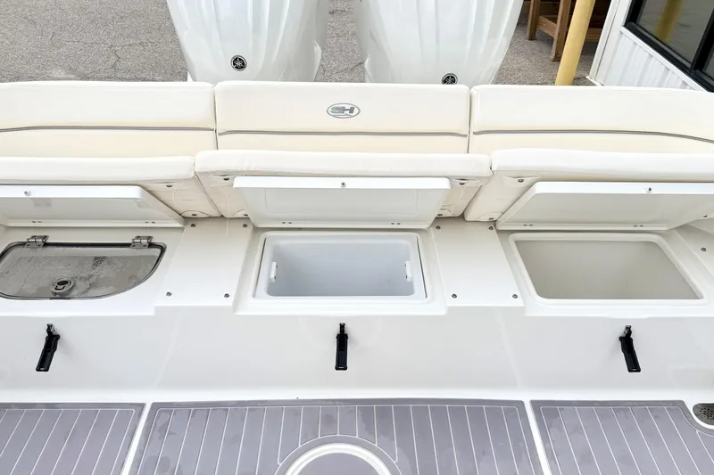 Slide: The Image of 2023 Sea Hunt Escape 28 boat with open storage compartments and cushioned seating. - 4