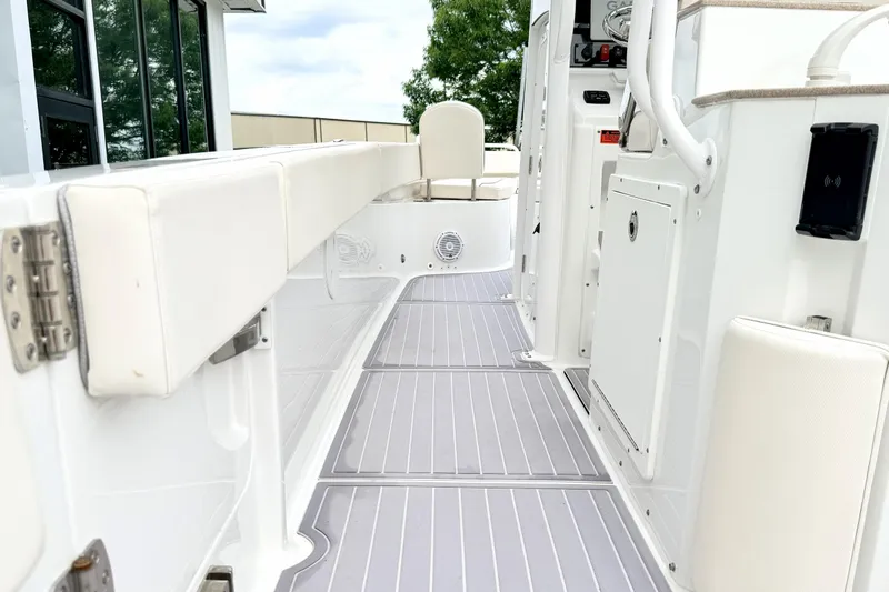 Slide: The Image of 2023 Sea Hunt Escape 28 boat interior with white seating and gray flooring. - 9