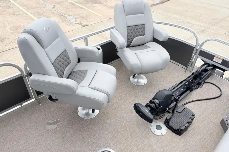Slide: The Image of 2021 Ranger 223FC boat interior with two gray captain chairs and a trolling motor. - 11