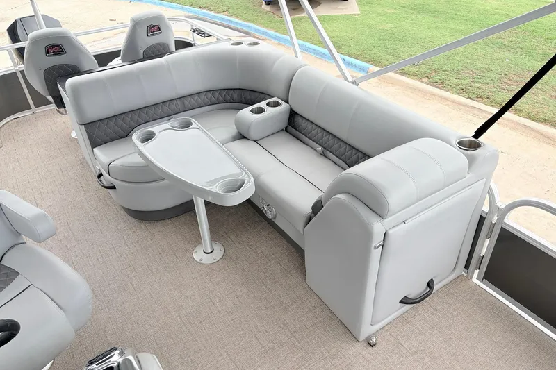 Slide: The Image of 2021 Ranger 223FC boat interior with gray seating, table, and cup holders. - 22