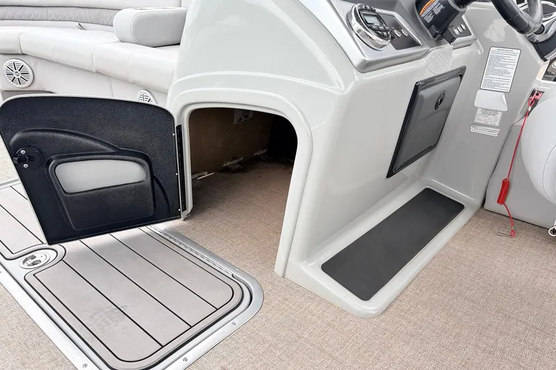 Slide: The Image of 2021 Ranger 223FC boat interior with open storage compartment and control panel. - 31