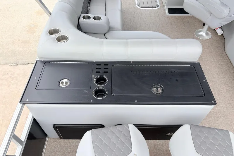 Slide: The Image of 2021 Ranger 223FC boat interior with seating, cup holders, and storage compartments. - 40
