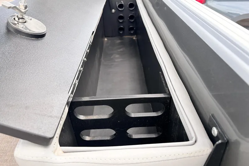 Slide: The Image of Open storage compartment in a 2021 Ranger 223FC boat, featuring a secure latch mechanism. - 46