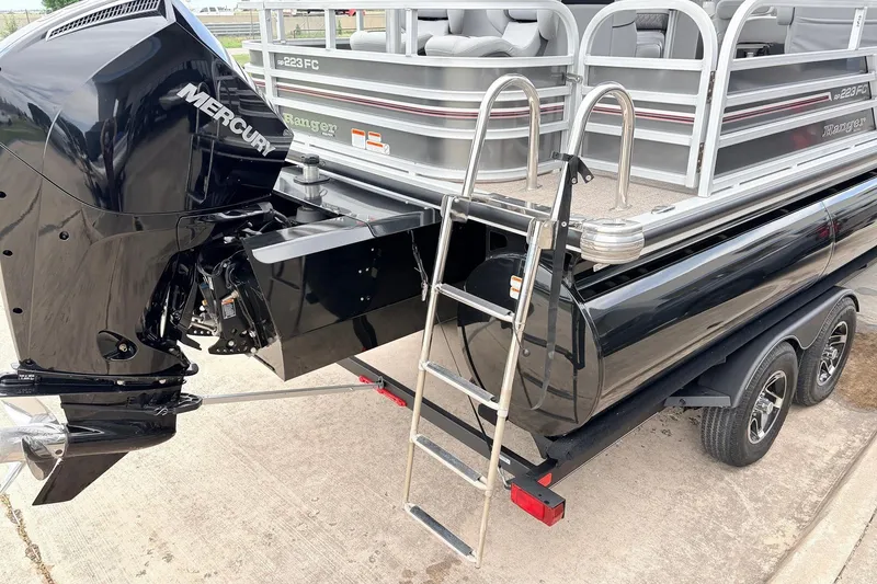 Slide: The Image of 2021 Ranger 223FC pontoon boat with Mercury engine and trailer, featuring a boarding ladder. - 8