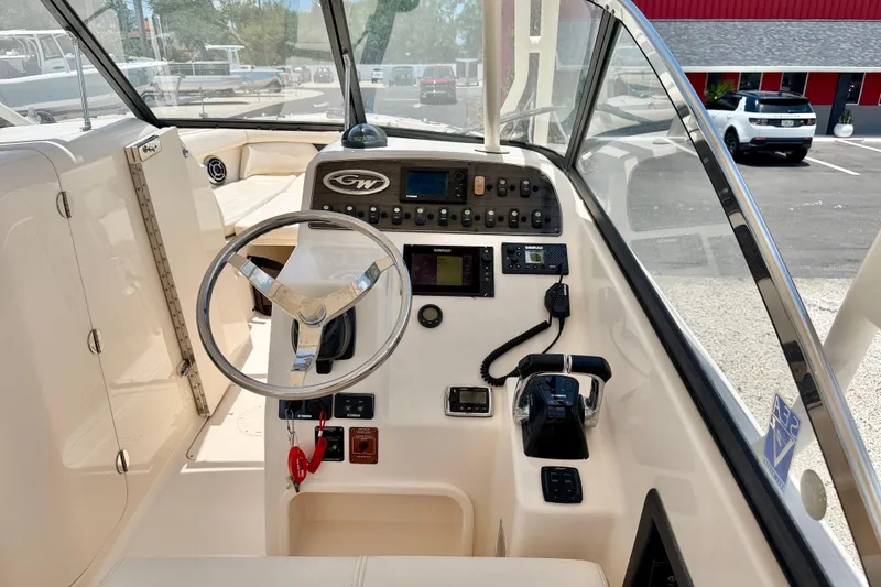 Slide: The Image of 2015 Grady-White Freedom 275 boat cockpit with steering wheel and control panel. - 13