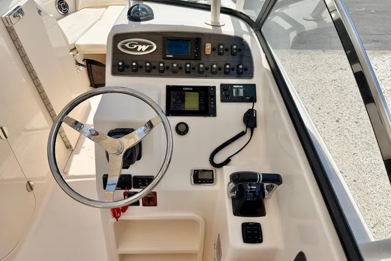 Slide: The Image of 2015 Grady-White Freedom 275 boat dashboard with steering wheel and control panel. - 14