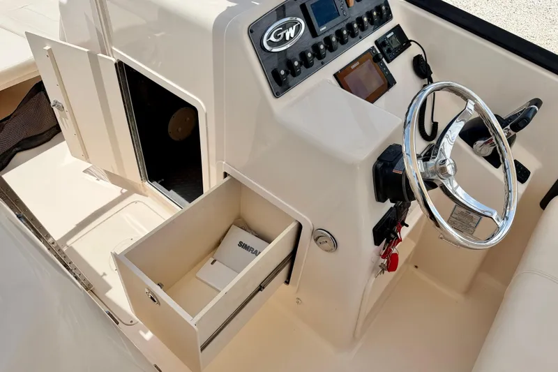Slide: The Image of 2015 Grady-White Freedom 275 boat helm with storage compartments and steering wheel. - 15