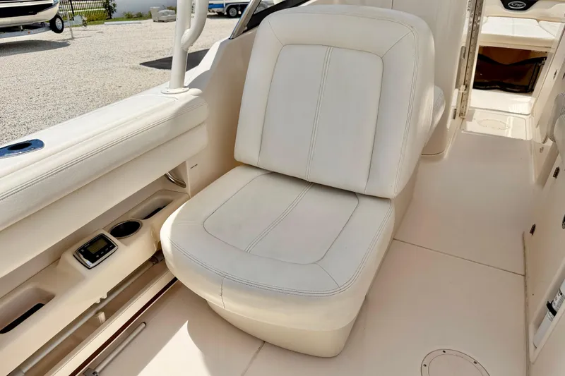 Slide: The Image of 2015 Grady-White Freedom 275 boat interior with white cushioned seating. - 24