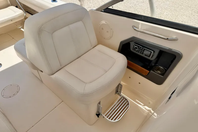 Slide: The Image of 2015 Grady-White Freedom 275 boat interior with cushioned seat and control panel. - 26
