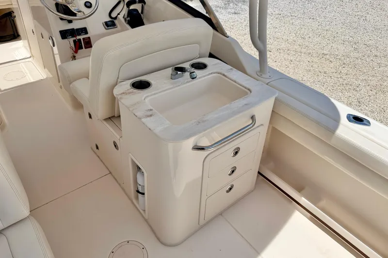 Slide: The Image of 2015 Grady-White Freedom 275 boat interior with sink and storage drawers. - 27