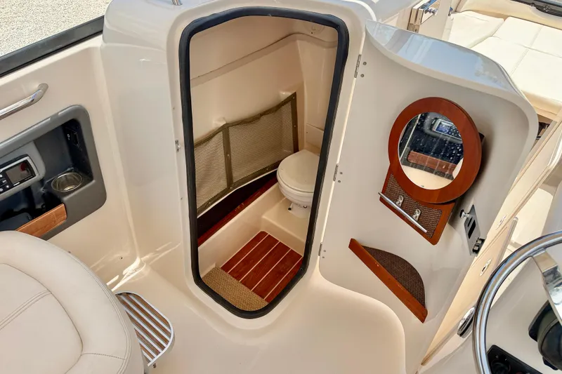 Slide: The Image of 2015 Grady-White Freedom 275 boat interior with compact restroom and mirror. - 31
