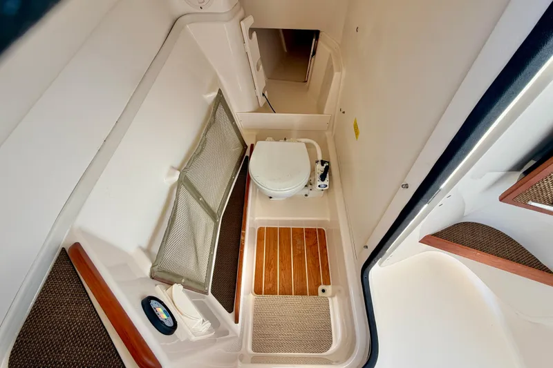 Slide: The Image of Interior of 2015 Grady-White Freedom 275 boat, featuring a compact marine toilet. - 32