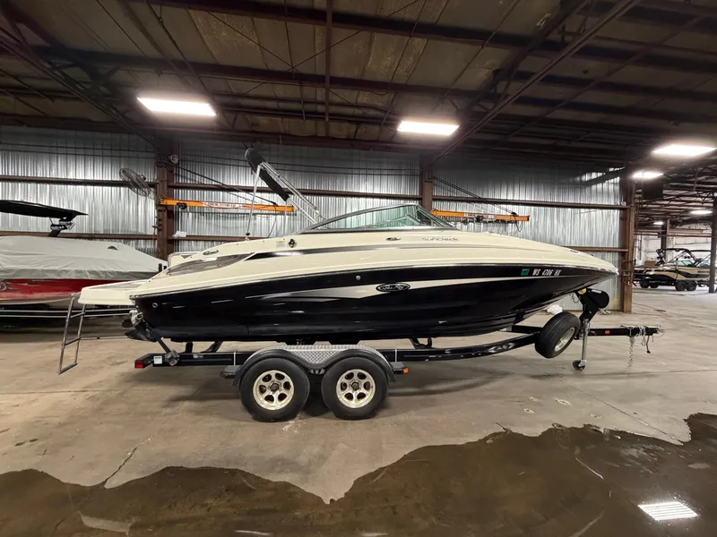 Slide: The Image of 2012 Sea Ray 220 Sundeck boat in warehouse on trailer. - 50