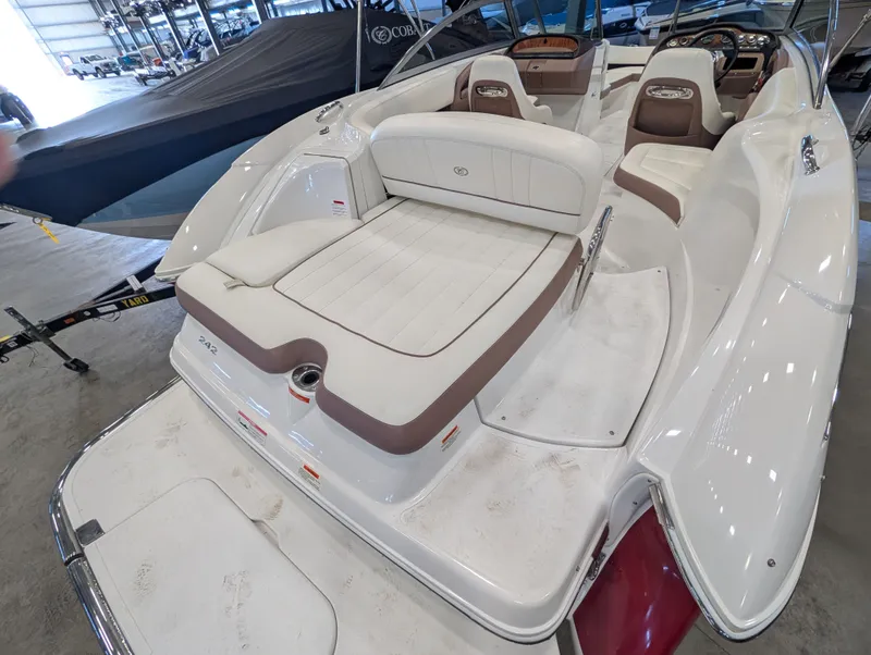Slide: The Image of 2011 Cobalt 242 boat with white and brown interior in a storage facility. - 8