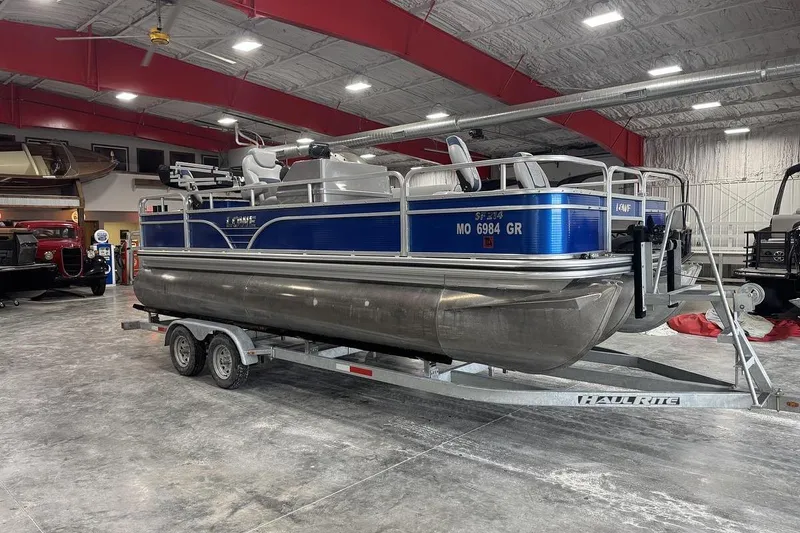 The Image of 2018 Lowe SF 214 Sport Fish pontoon boat on trailer in indoor showroom. - 1