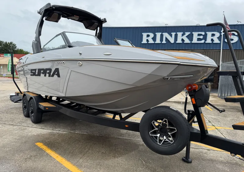 Slide: The Image of 2026 Supra SL 450 boat on trailer outside Rinker's store. - 3