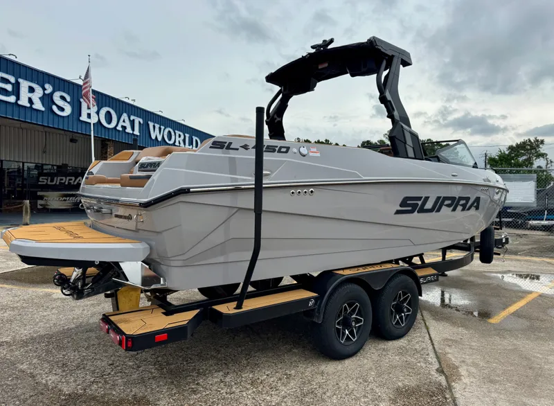 Slide: The Image of 2026 Supra SL 450 boat on trailer outside dealership. - 5