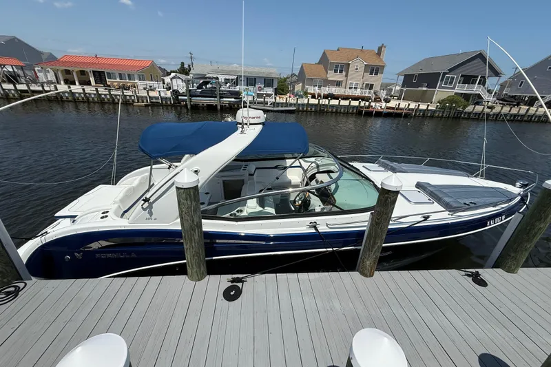 Slide: The Image of 2012 Formula 350 Sun Sport boat docked at a marina, featuring a sleek blue and white design. - 2