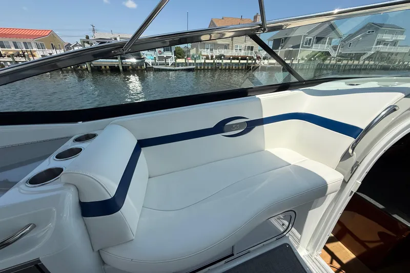 Slide: The Image of 2012 Formula 350 Sun Sport boat interior with white seating and blue accents by the water. - 25