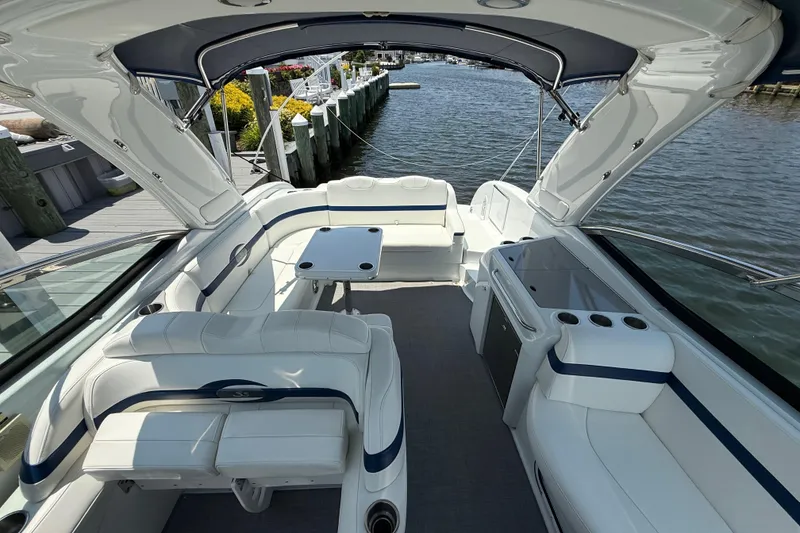 Slide: The Image of 2012 Formula 350 Sun Sport boat interior with white seating and table, docked by the water. - 27