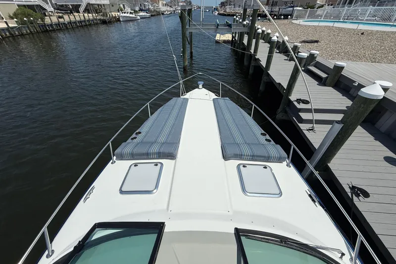 Slide: The Image of 2012 Formula 350 Sun Sport boat docked, featuring spacious deck and striped cushions. - 31