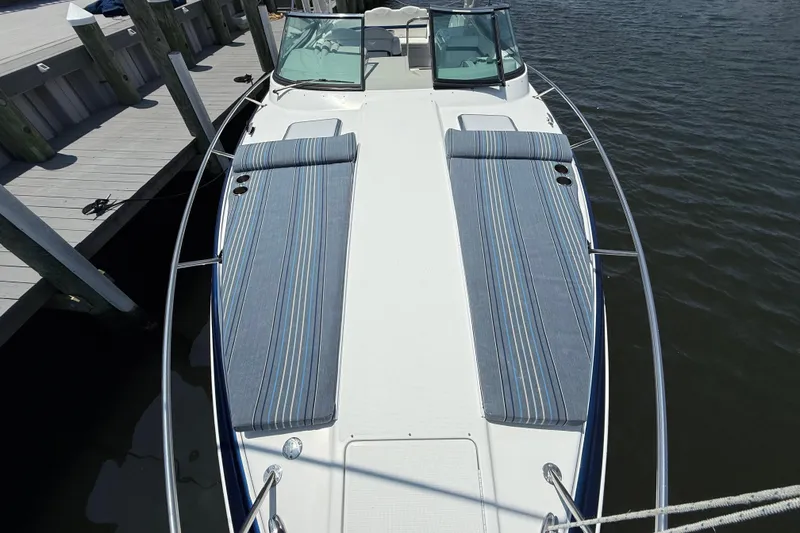 Slide: The Image of 2012 Formula 350 Sun Sport boat docked, featuring striped sunbathing cushions on deck. - 32