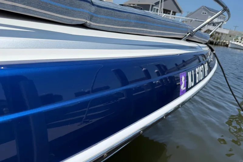 Slide: The Image of 2012 Formula 350 Sun Sport boat docked, featuring sleek blue hull and registration number. - 50