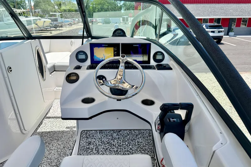 Slide: The Image of 2021 Twin Vee 240 GFX DC boat cockpit with steering wheel and navigation display. - 13