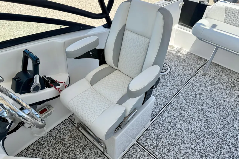 Slide: The Image of Captain's chair in 2021 Twin Vee 240 GFX DC boat, featuring sleek design and controls. - 22
