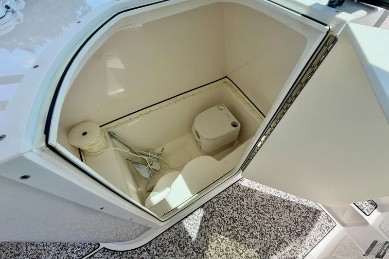 Slide: The Image of 2021 Twin Vee 240 GFX DC boat storage compartment with portable toilet and anchor. - 28