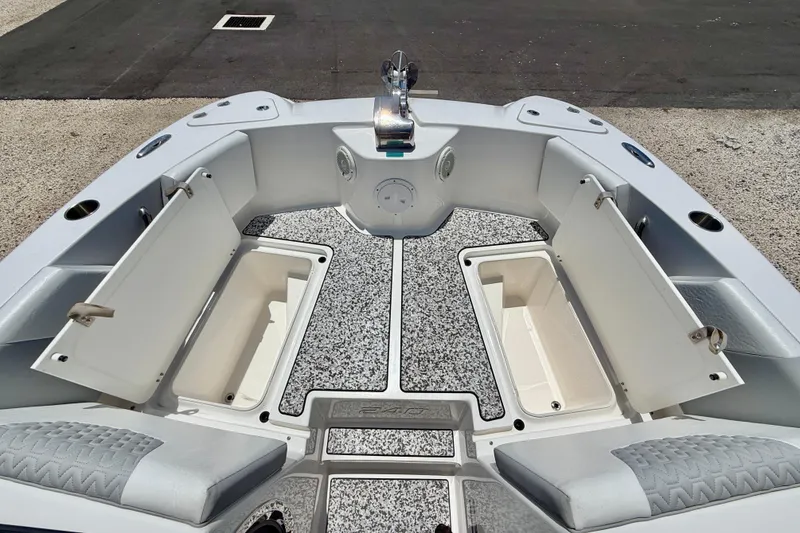 Slide: The Image of 2021 Twin Vee 240 GFX DC boat interior with open storage compartments and cushioned seating. - 30