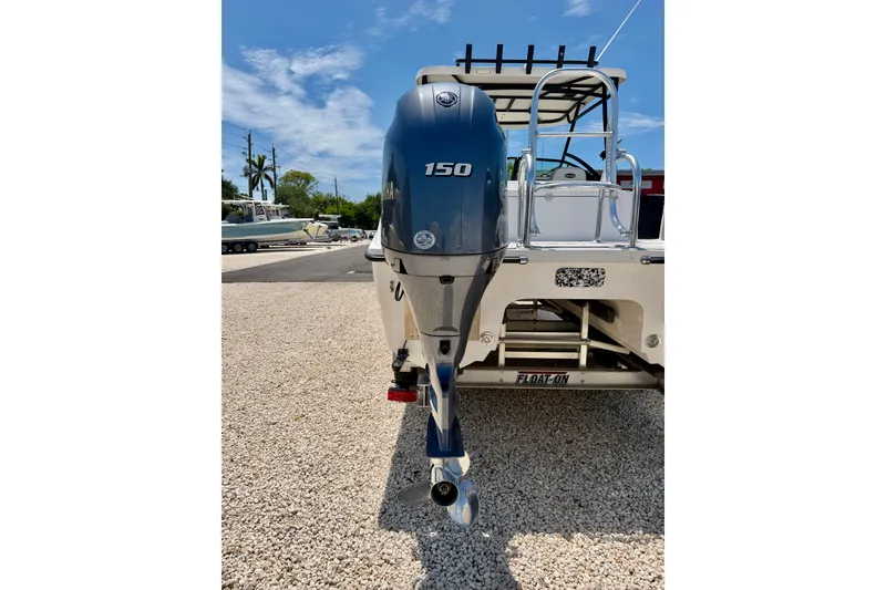 Slide: The Image of 2021 Twin Vee 240 GFX DC boat with a 150 HP outboard motor, parked on gravel. - 38