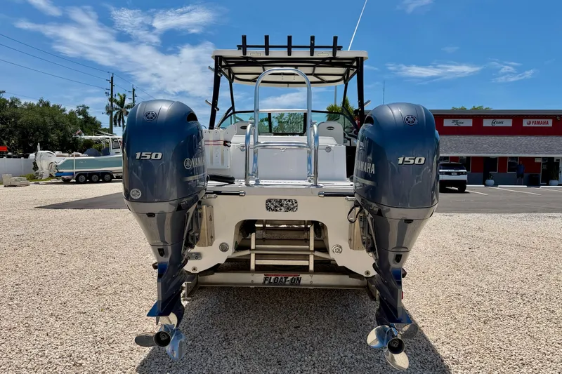 Slide: The Image of 2021 Twin Vee 240 GFX DC boat with dual Yamaha 150 engines, parked on gravel. - 6