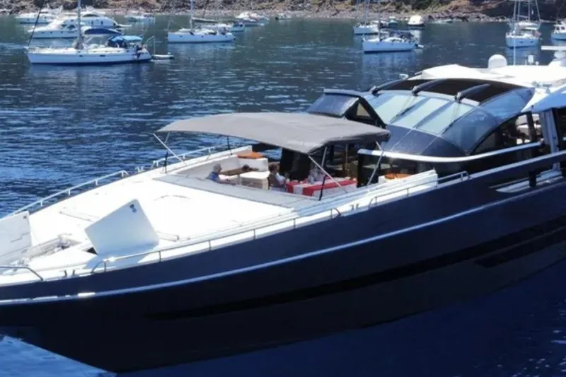 Slide: The Image of Luxury Baia ONE HUNDRED yacht, 2011 model, anchored in a serene bay with other boats. - 78