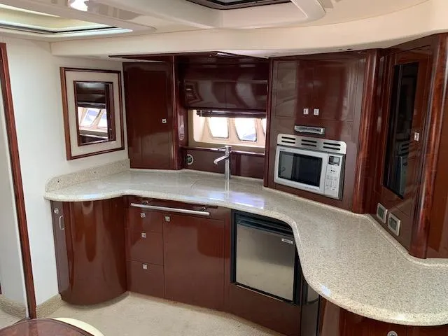 Slide: The Image of Luxurious 2008 Sea Ray Sundancer yacht kitchen with modern appliances and elegant wood cabinetry. - 2