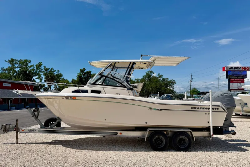The Image of 2016 Grady-White Journey 258 boat on trailer, parked outdoors under clear blue sky. - 0