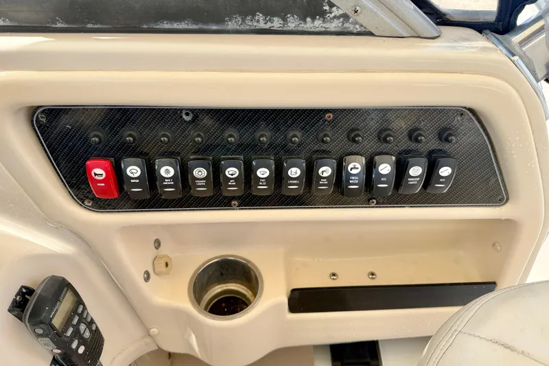 Slide: The Image of Control panel of a 2016 Grady-White Journey 258 boat with labeled switches. - 10